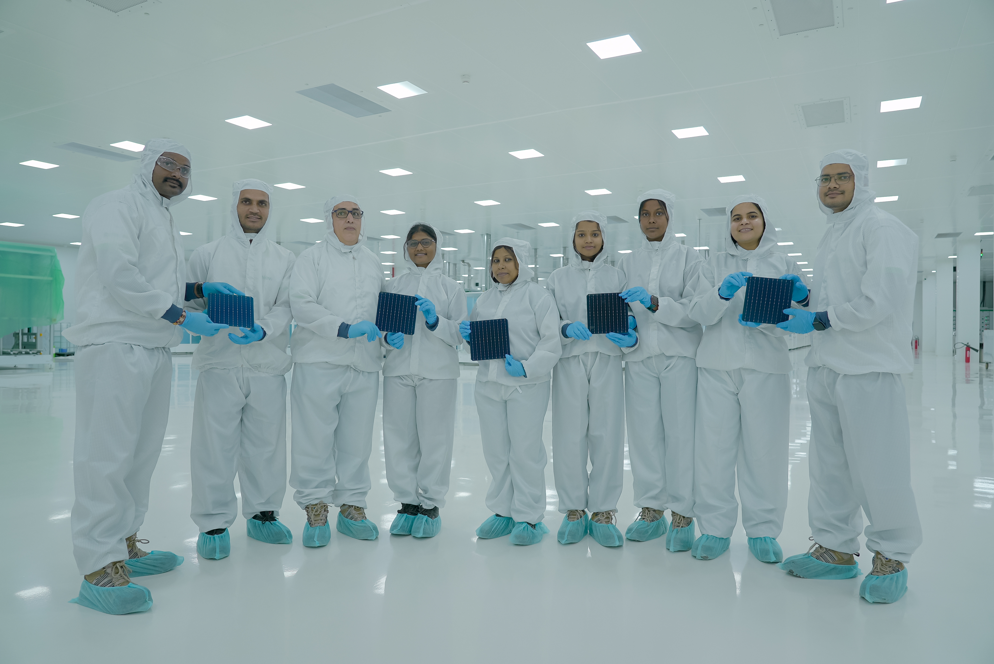 ReNew cleanroom team holding solar cells